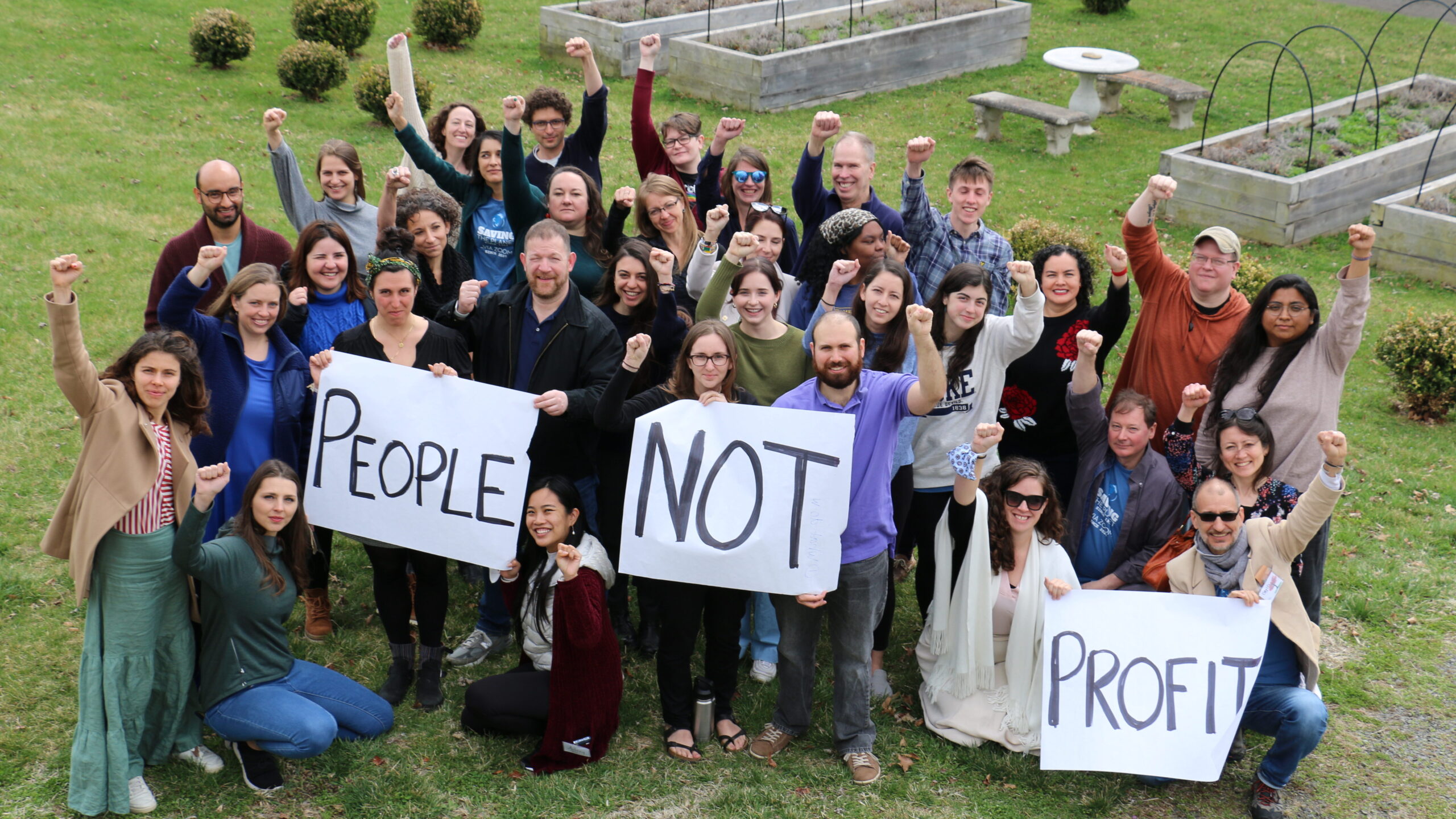 CIEL Team holds sign "People Not Profit"